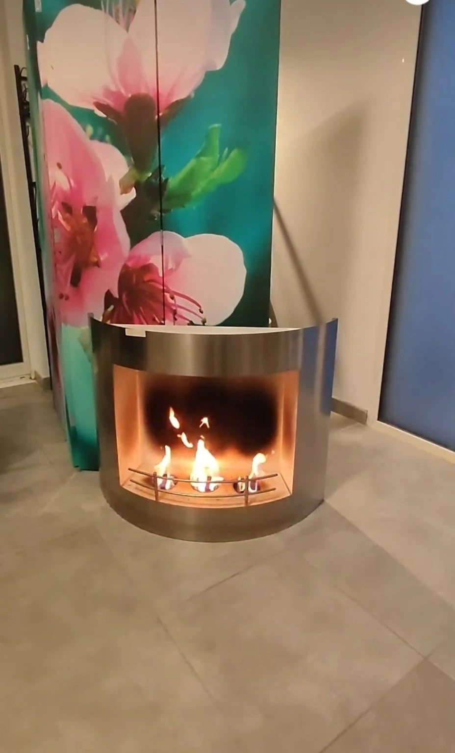 Détail chaleureux du cabinet avec la cheminée et le paravent fleuri