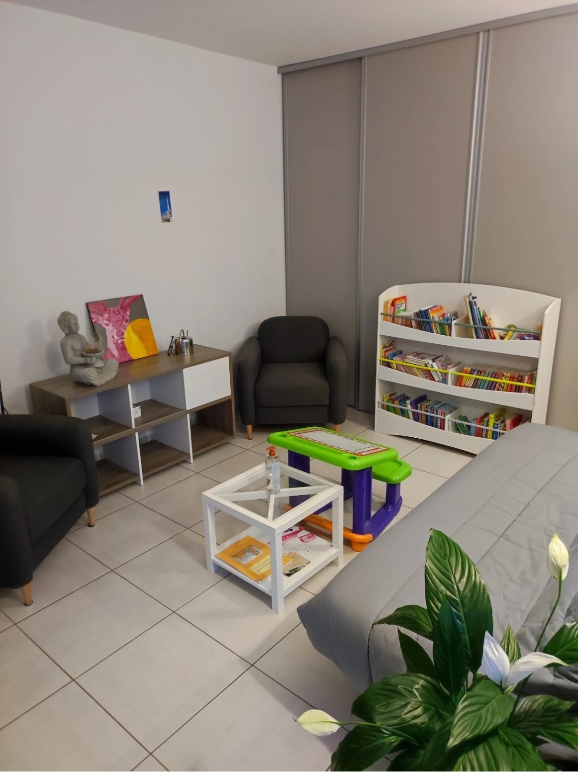 La salle d’attente du cabinet, avec fauteuils, canapé et coin enfants